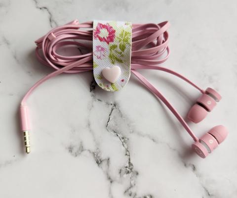 Faux leather cable tidy wrapped about a pair headphones